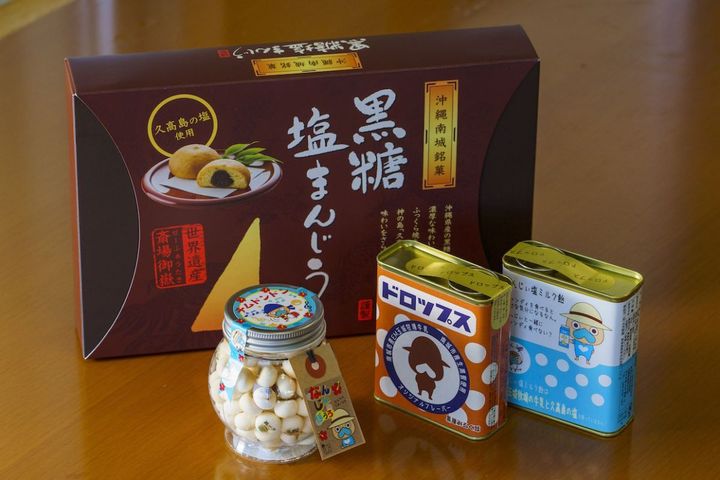 手前左から「なんじぃぼうろ」550円、「なんじぃドロップス黒糖みるく味」486円、「なんじぃ塩ミルク飴」486円、奥「黒糖塩まんじう」9個入り1650円