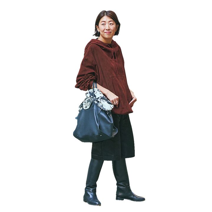 赤茶色のフーディにエコレザーのハーフパンツとロングブーツを合わせたVERYライターの私服コーデ