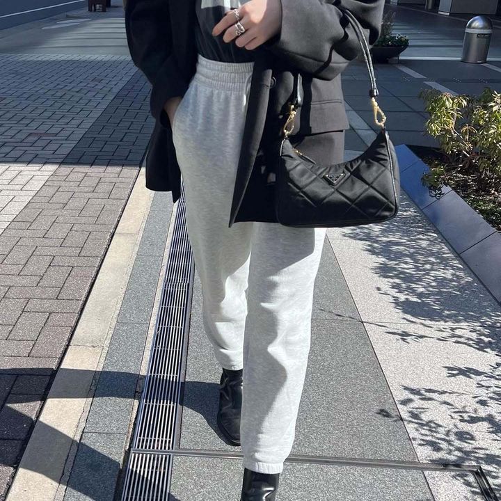 プラダのバッグを持って歩く女性