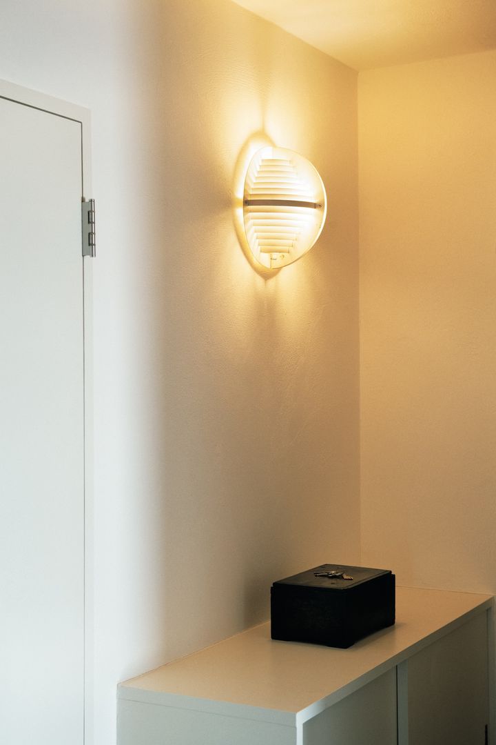 改築前の建物の空気感を残した玄関。照明は元のまま。壁と靴箱は塗り直し、李朝の木箱を置いた。