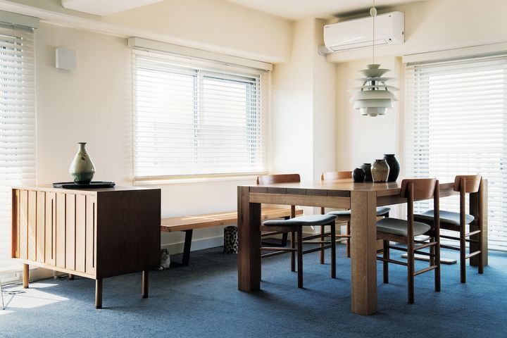 窓際のダイニング。１×２ｍの大テーブルは〈HIKE〉オリジナル。改築設計は〈TIMELESS LIVING〉。ウールの絨毯など天然素材を使う方針にも共感した。