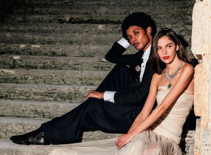 〈右〉『宝島』で描かれる熱帯植物に敬意を表し、ヤシの葉の冠をイメージ。アール構造がしなやかにボディにフィットし美しい孤を描く。47.93カラットの特別なコロンビア産エメラルドを採用。 「パルムレ メルヴェイユーズ」 取り外し可能なペンダント付きネックレス&クリップ YG×WG×カボションカットエメラルド×ダイヤモンド 参考商品／VAN CLEEF & ARPELS ドレス 参考商品／ANIYE RECORDS〈左〉『宝島』に登場するディヴィット・スモレットが船長を務めたヒスパニオラ号の舵を優美にかたどった作品。 「スモレット」 クリップ RG×YG×クッションカットピンクスピネル（3石計4.46カラット）×ピンクスピネル×ダイヤモンド 参考商品／VAN CLEEF & ARPELS ジャケット ￥605,000／RALPH LAUREN PURPLE LABEL パンツ シューズともに参考商品／ともにDRIES VAN NOTEN シャツ／スタイリスト私物