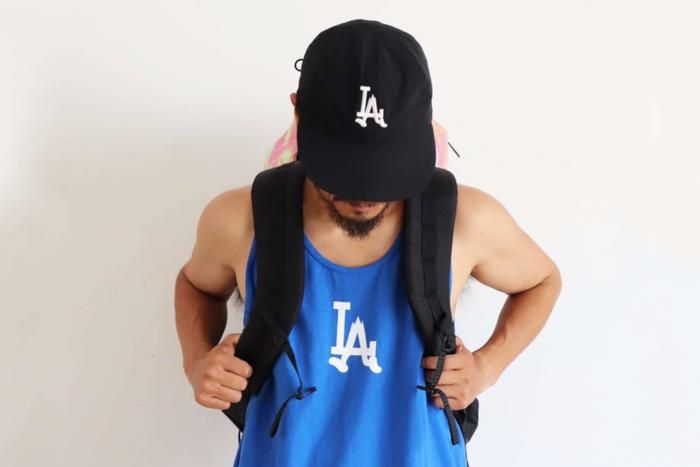 SAVE SHOCKのLOVE ATHLETESタンクとキャップを着けた男性