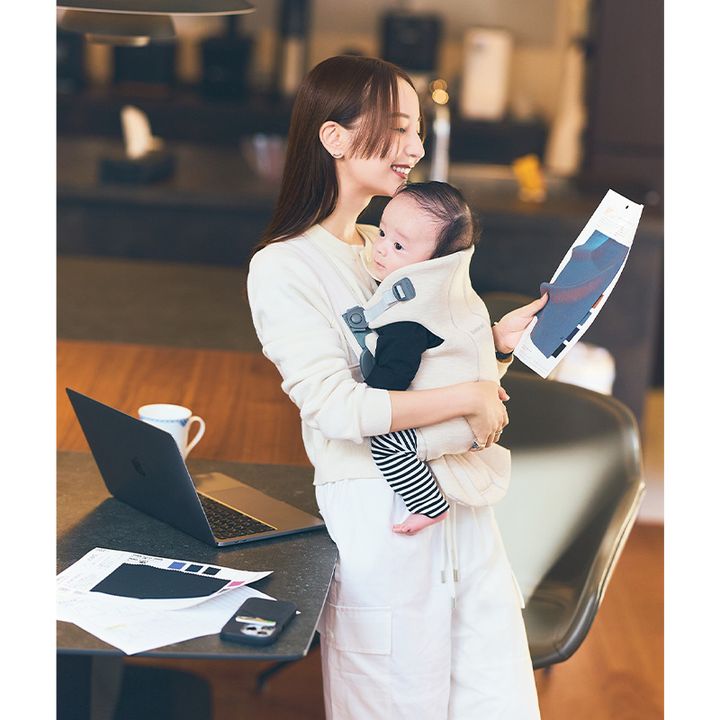 赤ちゃんを抱っこしながら仕事をする佐藤涼実さん