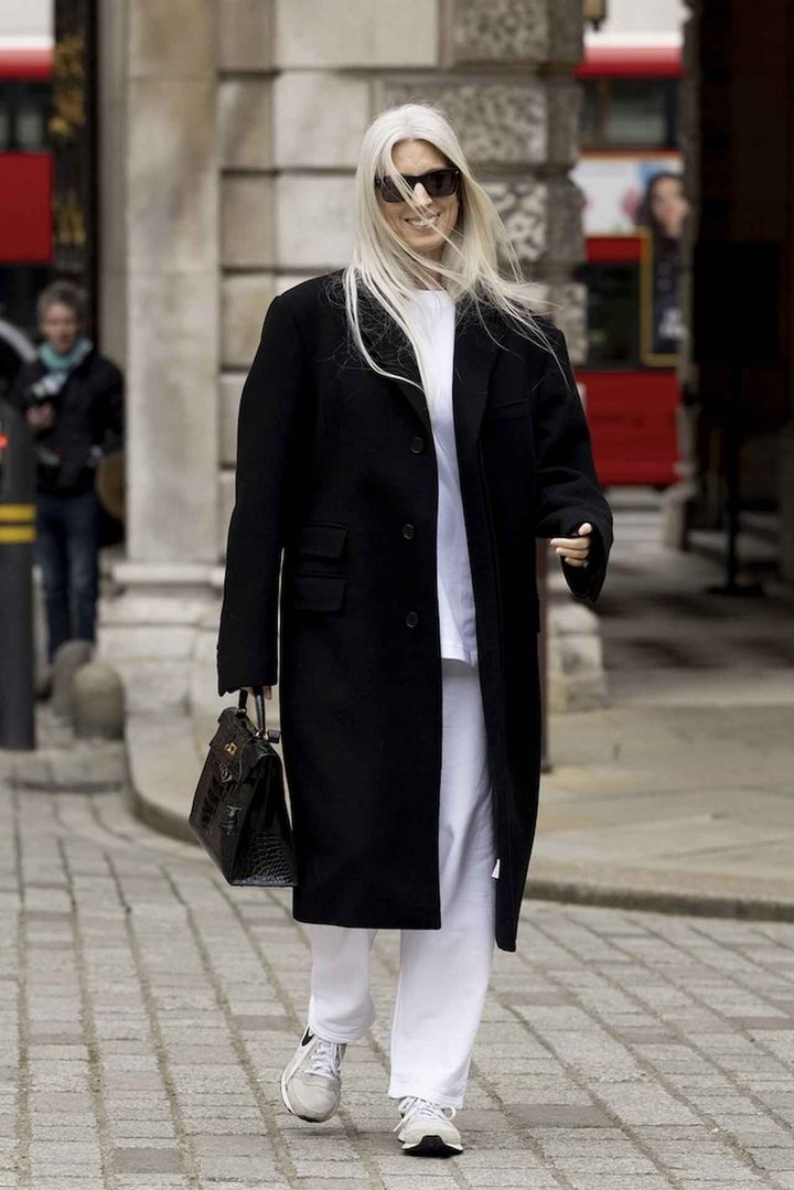 画像: シックな黒コートはスニーカーで抜け感をプラス