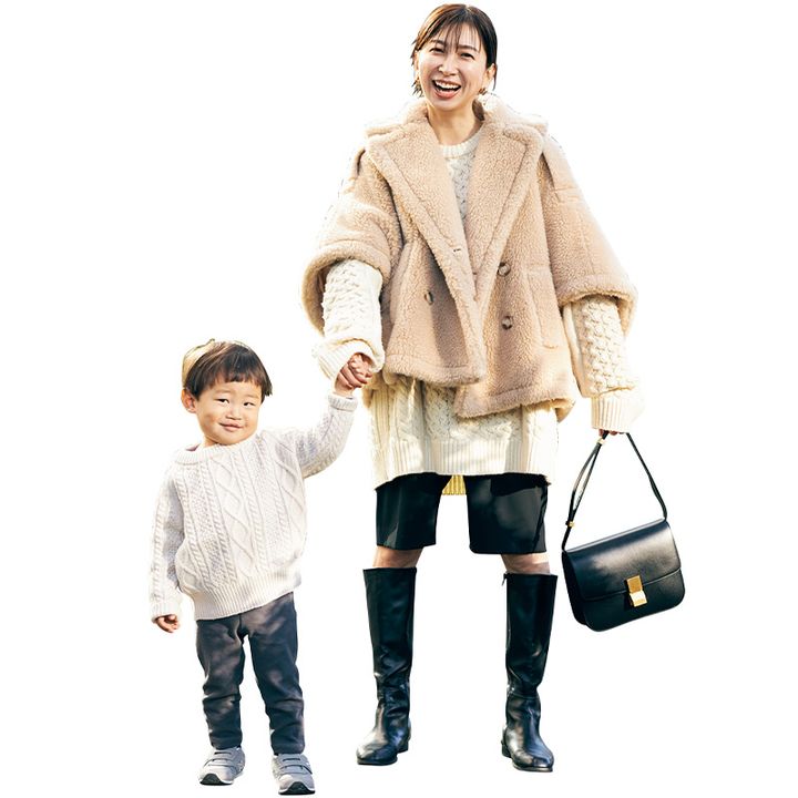 白ニットと黒のハーフパンツにケープ型のテディアウターを羽織り息子さんと手を繋いで微笑む読者
