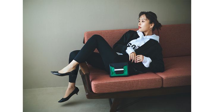 ロゴフーディに黒ジャケットを羽織りレギンスと私物のTHE ROWの黒ヒールパンプスを合わせた近藤千尋さんの着こなし