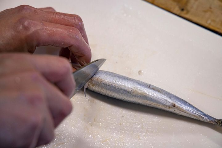 胸ビレの後ろから包丁を入れて頭を落とす