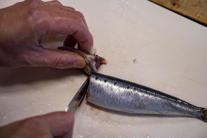 胸ビレの後ろから包丁を入れて頭を落とす