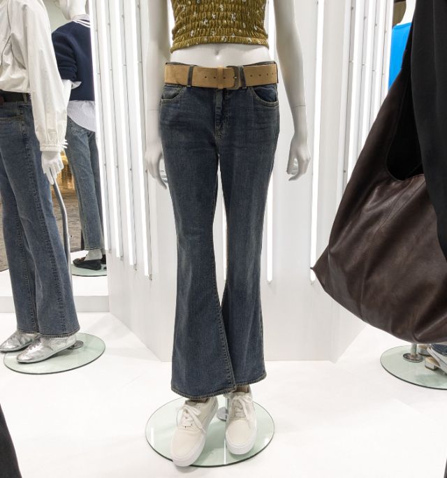 スリムフレアジーンズを着用