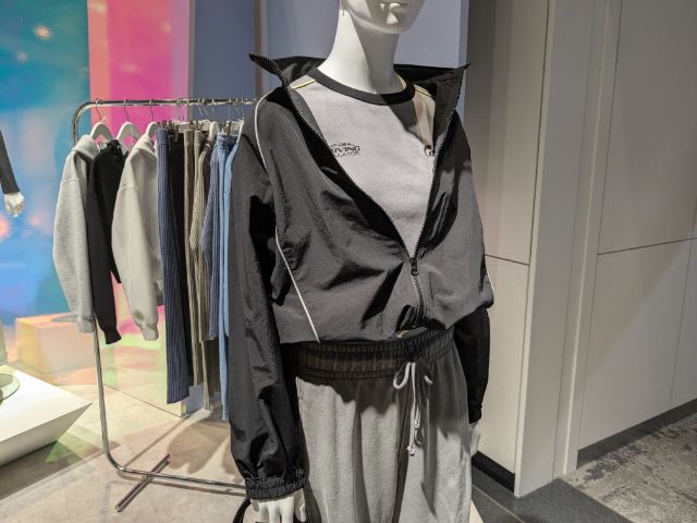 黒のナイロントラックジャケットを着用