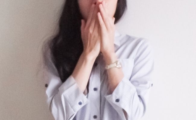 驚いて口元を隠す女性のイメージ