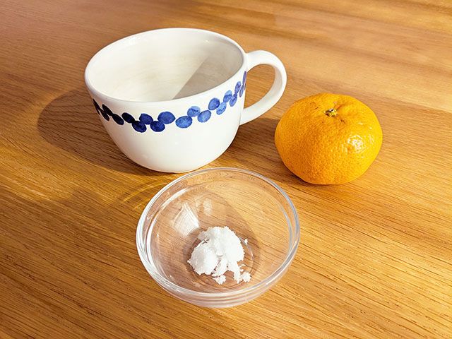 茶渋のついたマグカップとみかん、塩がテーブルに置かれている様子