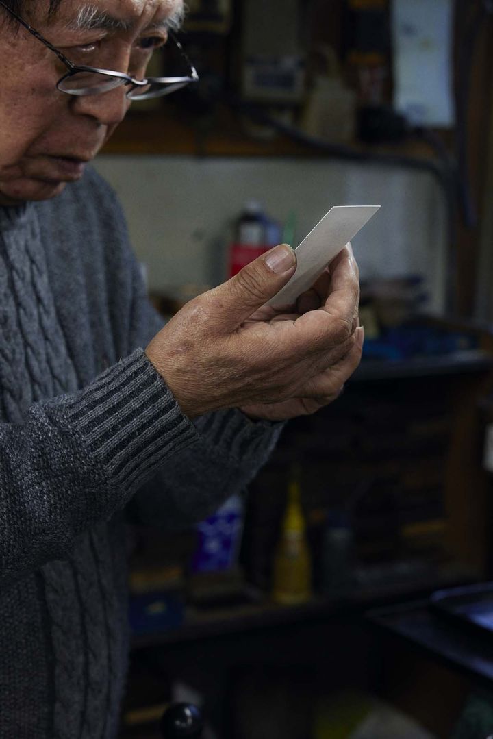名刺の仕上がりをチェックする中村明久さん