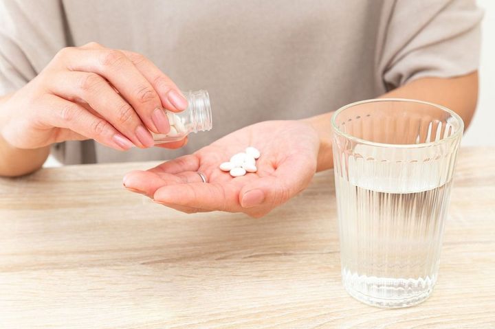 薬を手にのせる人