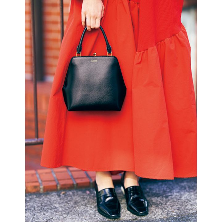 赤ワンピースに合わせたジルサンダーのハンドバッグと黒いシューズ