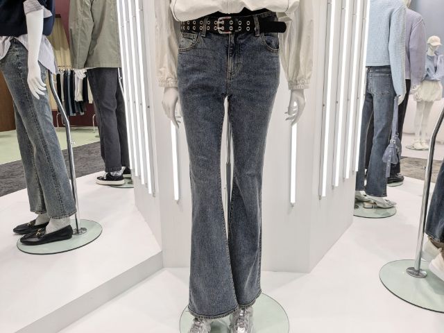 ウォッシュ加工したスリムフレアジーンズを着用