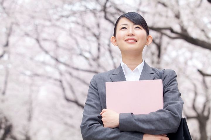 桜を見上げる新入社員の女性 会社員