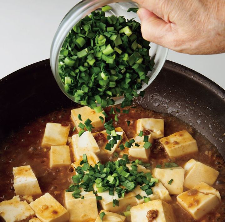 3分煮てにら、ごま油を入れて全体を混ぜる