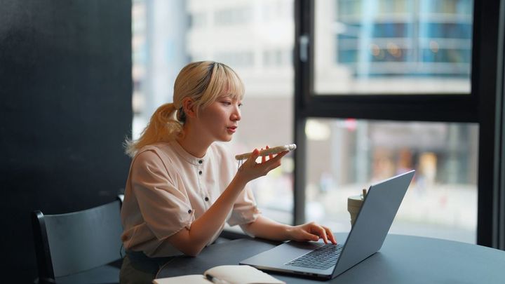 スマホで音声入力をしている女性