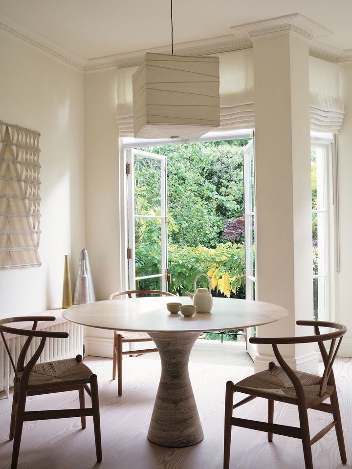 朝食コーナー。中央のテーブルは「アンジェロM」シリーズで、アリネアで調達。椅子はハンス・ウェゲナーの「CH24」ウィッシュボーン・チェア。奥に見える白と黄色の花瓶はローランド・ヴァン・デ・ヴェーゲ。その奥にある銀錫の花瓶は関根正文の作品。ペンダントシェードはイサム・ノグチの「AKARI」。左手の壁に飾られたアートはピーター・コリングウッド作の「M.72 No.3」。