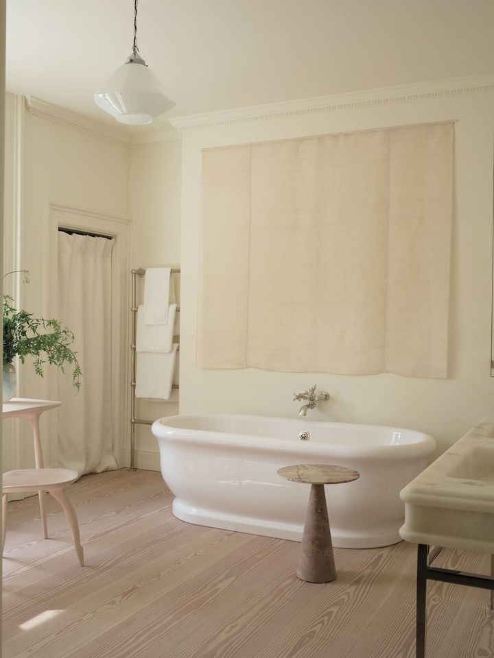 バスルーム。バスタブはザ・ウォーター・モノポリーで調達。トラバーチンのサイドテーブルはローズ・ウニアック。バスタブの奥の壁にかかっているテキスタイルはリネンとマニラ麻の混紡素材で、ロ ーズ・ウニアック。