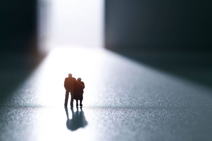 開いたドアの前に立つシニアの置物