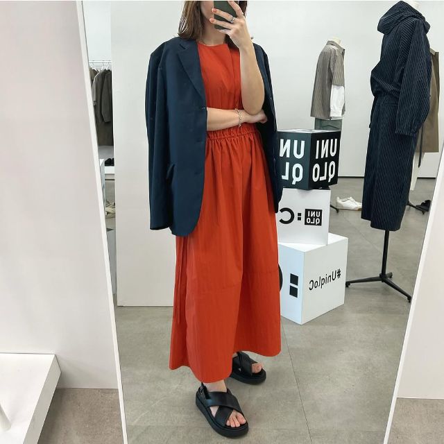 オレンジのギャザーワンピースノースリーブと感動ダブルジャケットリラックスフィットのコーデ