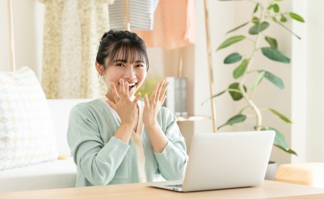 パソコンを見て喜ぶ女性