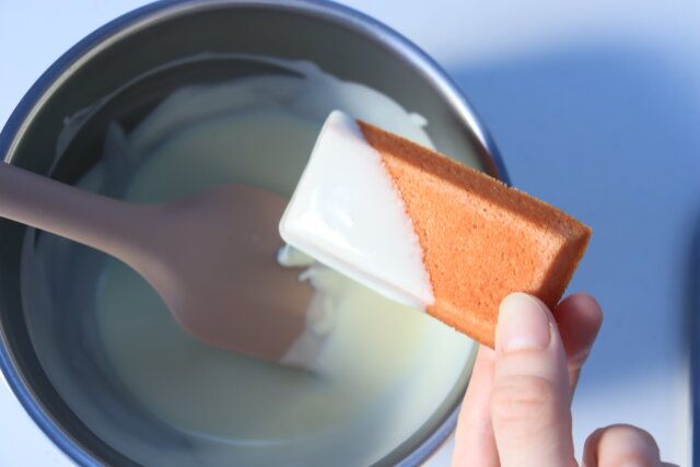 溶かしたホワイトチョコレートに冷めたフィナンシェをサッとくぐらせる。