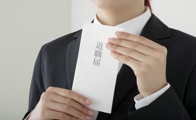 退職届を持つスーツ姿の女性