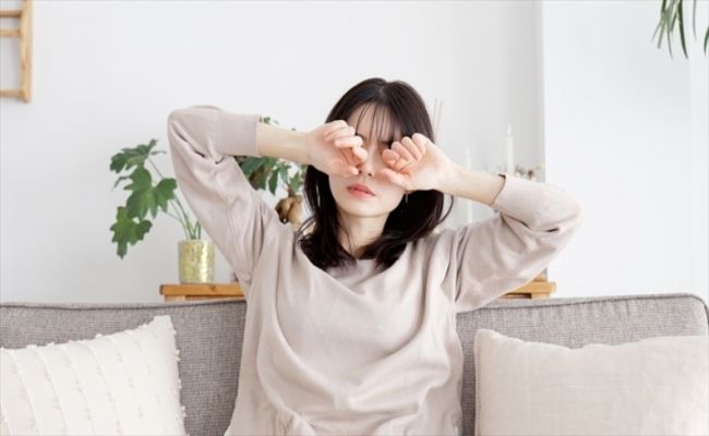 目を擦る女性