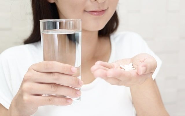 薬を飲む女性