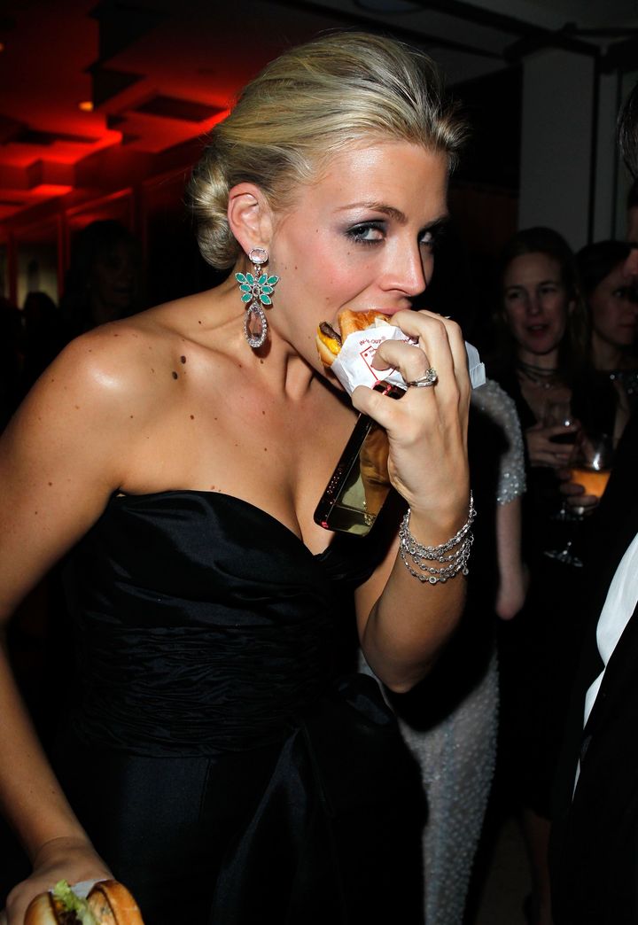 2011年、ハンバーガーにかぶりつくビジー・フィリップス。