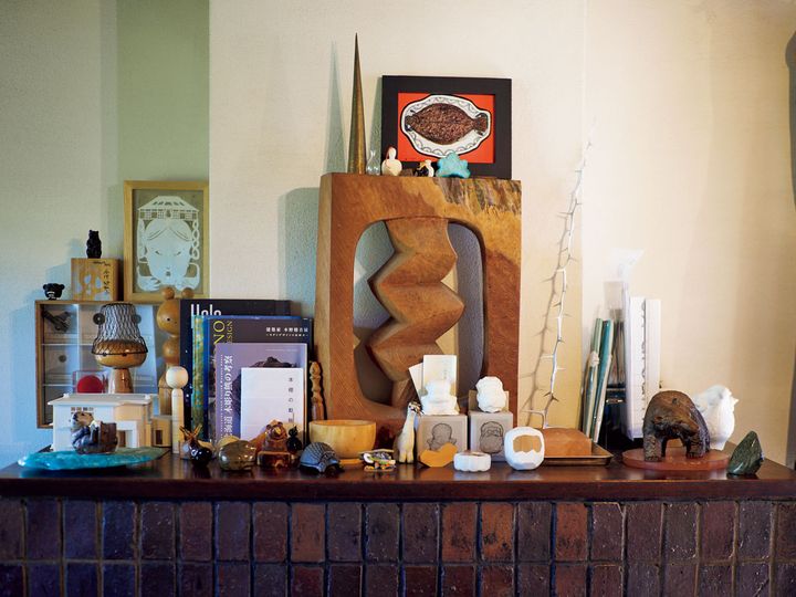 暖炉の上に、動物の置物とともに置かれる民藝関連の本