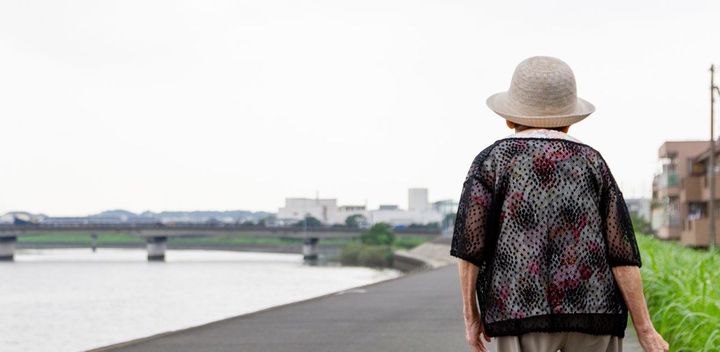 土手を歩くシニア女性