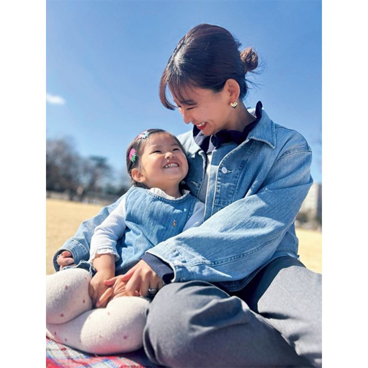 公園でシートに座るデニムジャケットを着たママと女の子