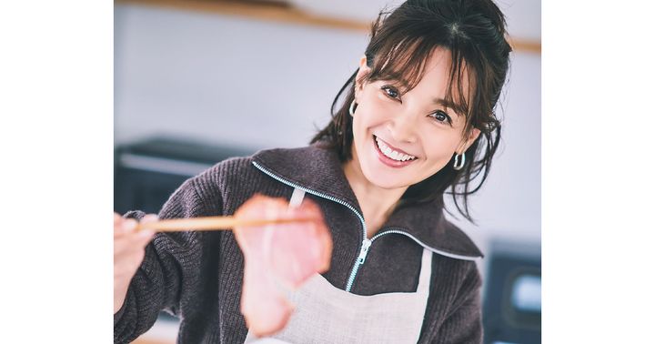 チャーシューをお箸で持ち上げて微笑む女優の国仲涼子さん