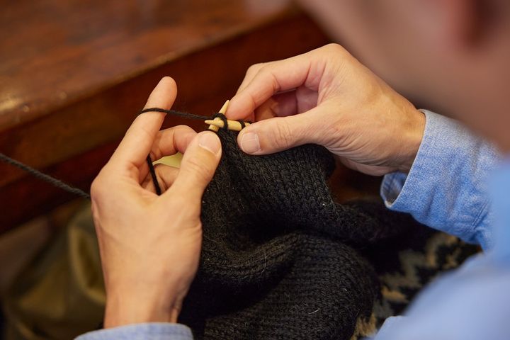セーターを編む参加者。コロナ禍をきっかけに編み物を始めたそう