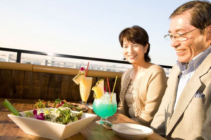 シニア男女がテラスで食事