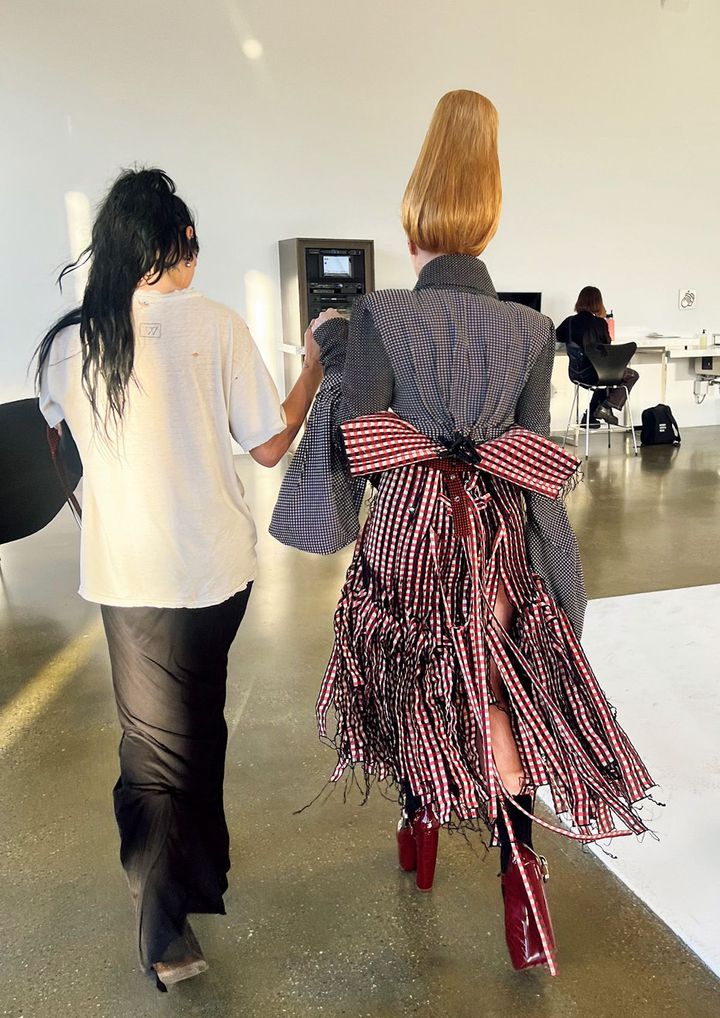 雑誌の撮影の合間のワンシーン。プラットフォームのシューズを履いたチャペルを支えるジェネシス。