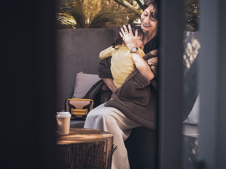 テラスで子どもを抱っこしてあやすママ