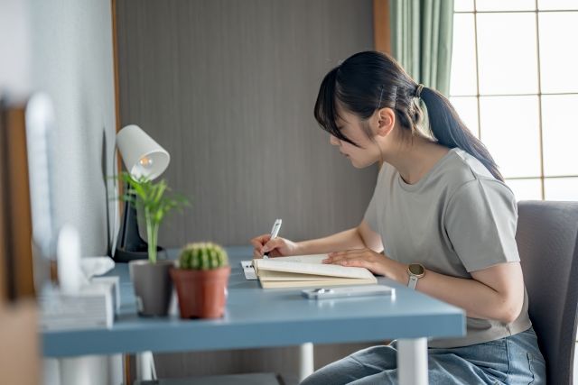 ノートに何かを書く女性