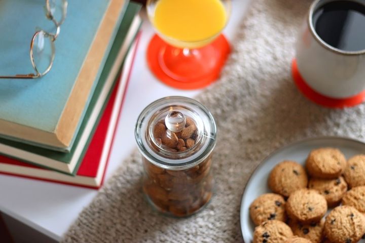 デスクのクッキーやコーヒー、ジュースやお菓子と本 おうち時間