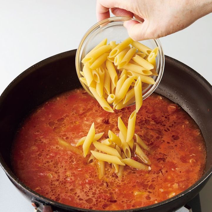 ツナを缶汁ごと加え、カットトマト、水、ペンネを入れ、ふたをして弱めの中火で10分煮る