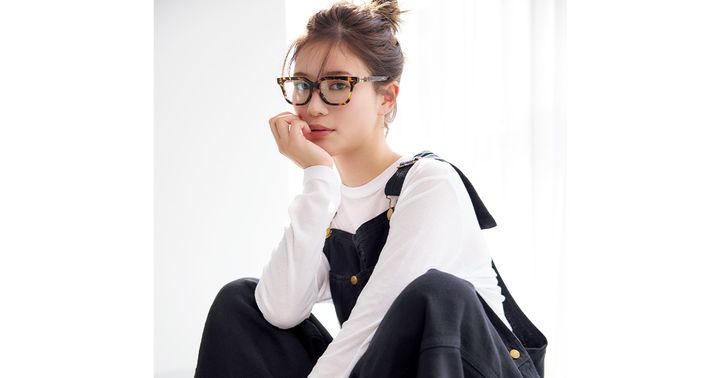 白のカットソーにブラックデニムのオーバーオールを着てメガネをかけた咲和希さん