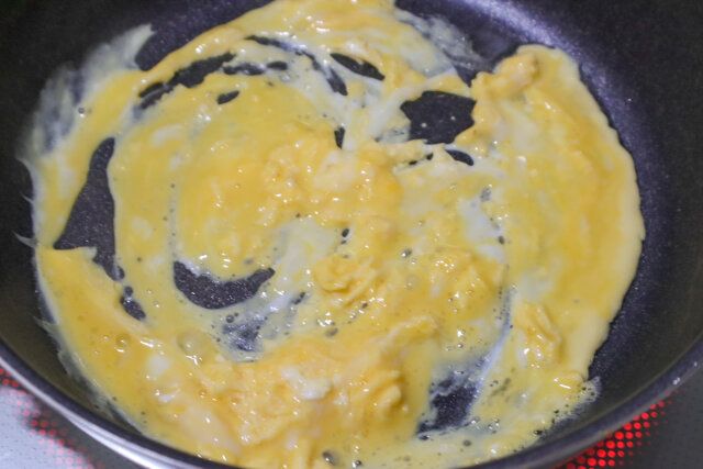 ボウルに卵を割りほぐし、ごま油を熱したフライパンに流す。