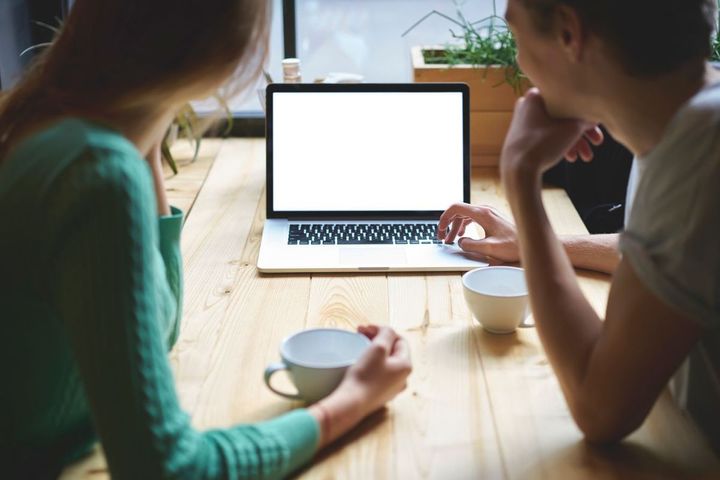 ラップトップで空白の画面を見る若者