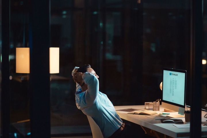 深夜の仕事中に机の上でリラックスしているビジネスマン
