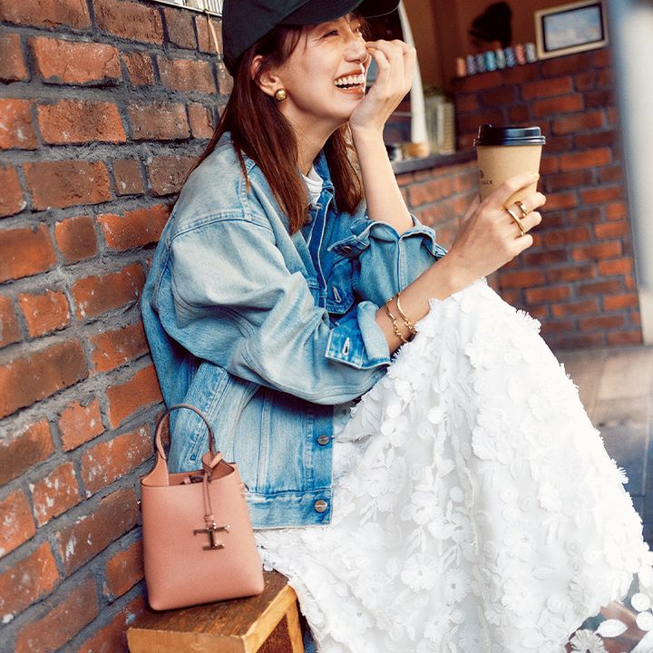 立体的な花柄の白スカートに、ヴィンテージ風のデニムジャケット